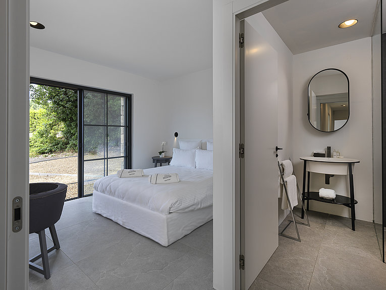 Althoff Villa Belrose in St. Tropez Côte d'Or Schlafzimmer mit Badezimmer und Blick auf in den Garten im Sommer